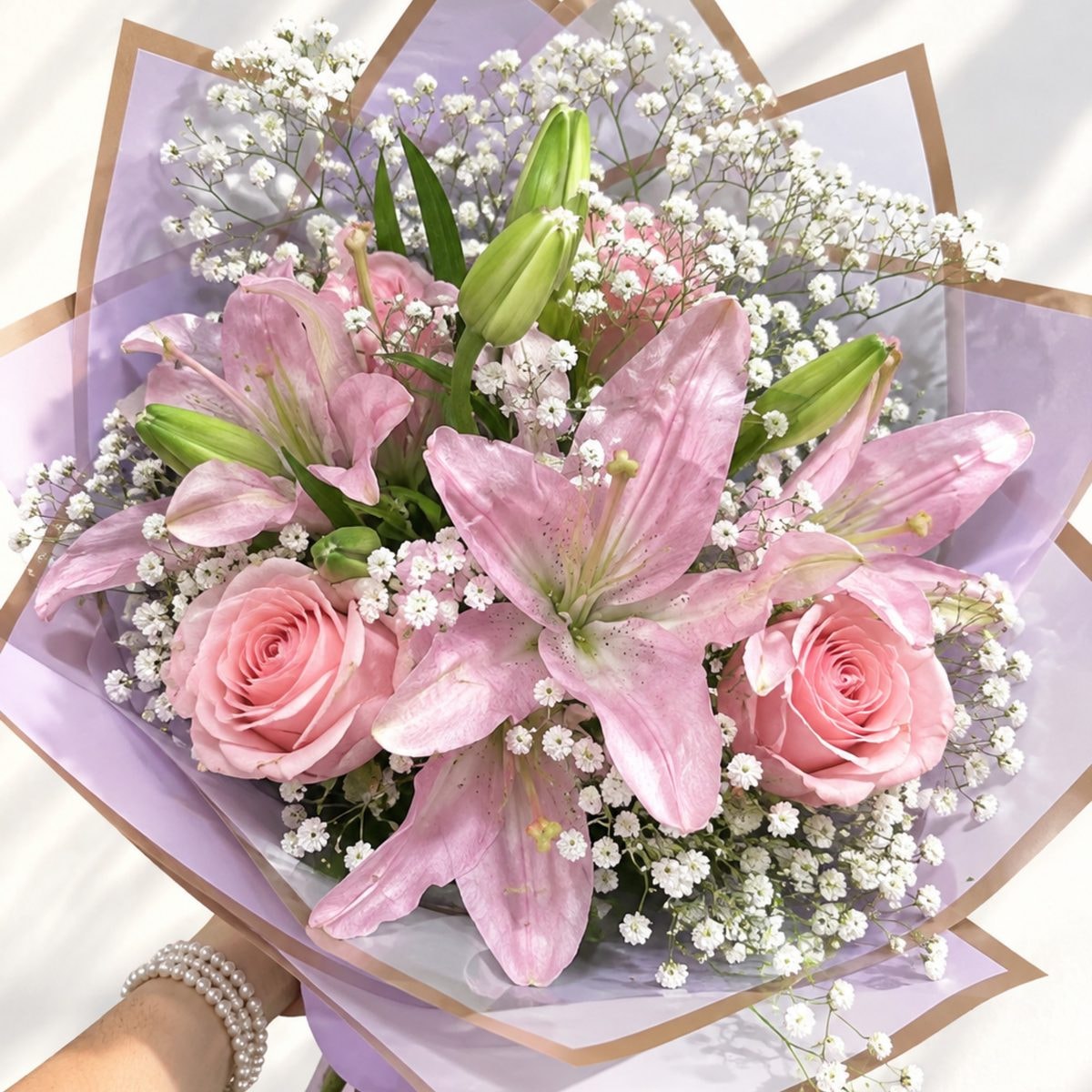 Imagen referencial generada con IA de Ramo de 8 rosas y 3 liliums rosados con ilusión blanca