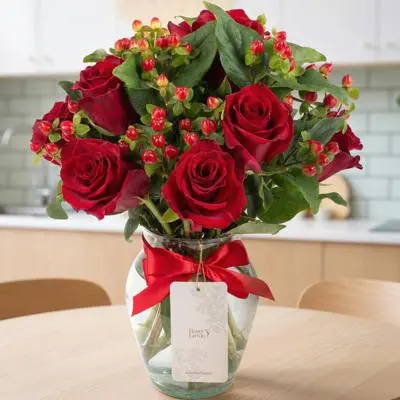 Antonia en Ánfora - florero con 9 rosas rojo e hypericum