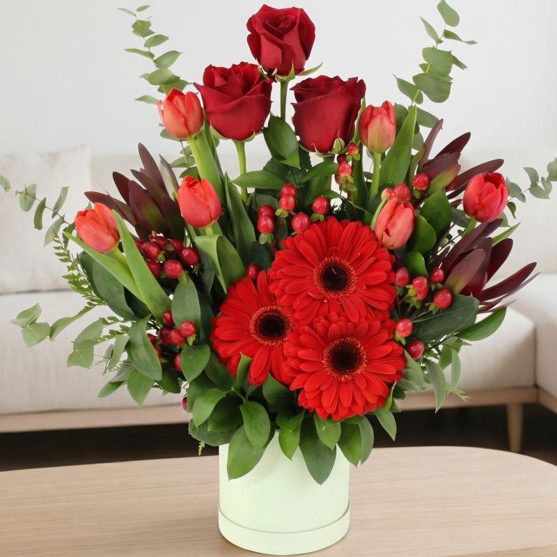 Altair Rojo en sombrerero - Arreglo floral con tulipanes, rosas y gerberas en color rojo - Imagen 1