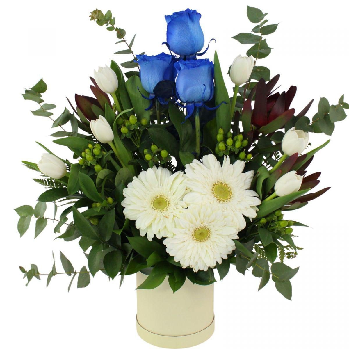 Altair Azul en sombrerero - Arreglo floral con tulipanes blancos, rosas azul, gerberas blanco y leucadendros - Imagen 1