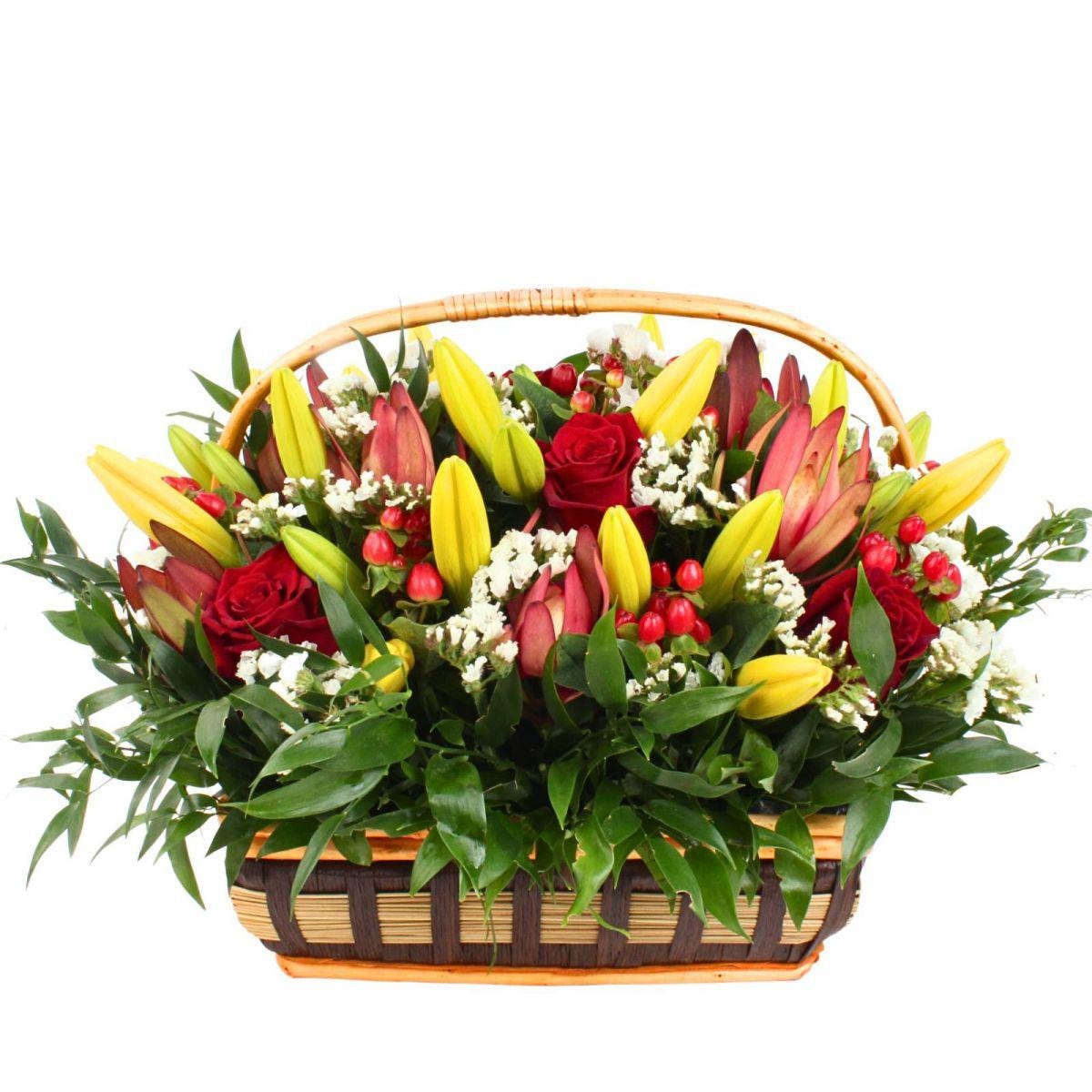 Florencia Amarillo Canasto - Arreglo en canasto con liliums amarillos, rosas rojas, hypericum rojo y leucadendro - Imagen 1