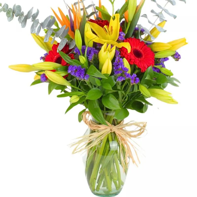 Abril en Florero - Arreglo floral en florero con gerberas rojas, liliums amarillos, aves del paraíso y statice morado